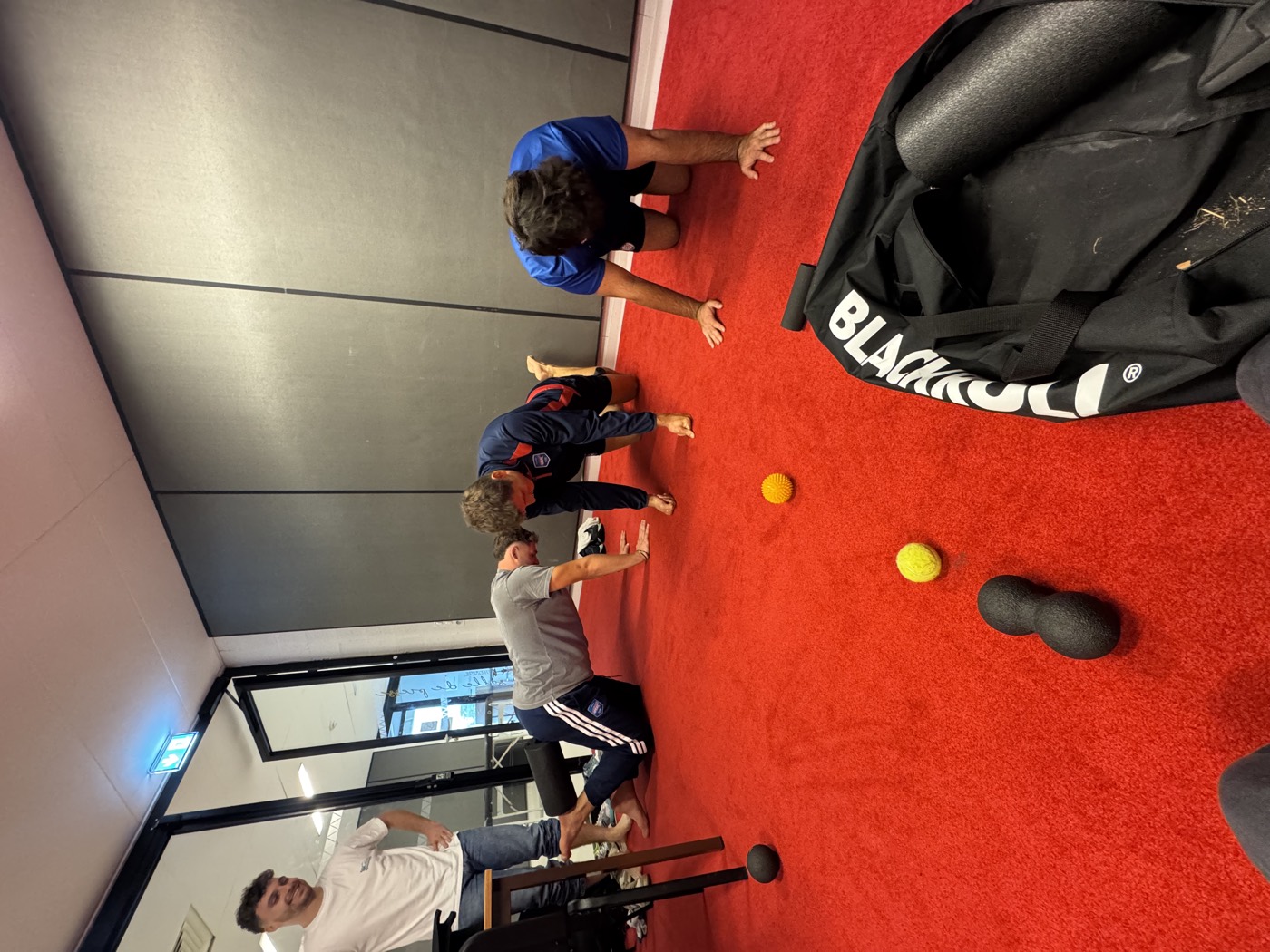 Joueurs de rugby en quadrupédie sur un tapis, séance de mobilité en club